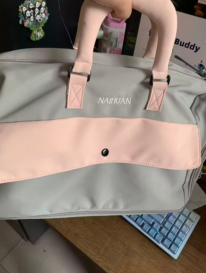 A buyer's photo of the Grey-Pink duffel on a desk beside a keyboard