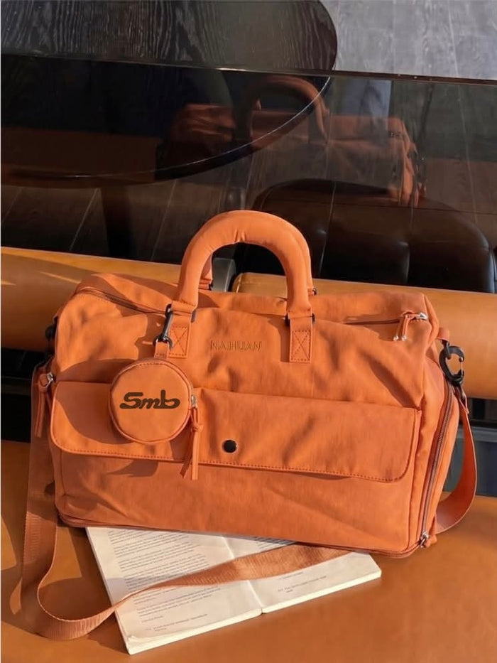 The Orange duffel on a dark surface