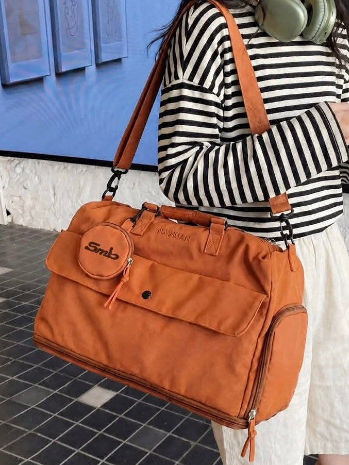 The Orange duffel worn on the shoulder