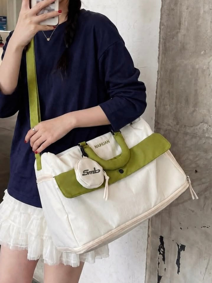 The White-Green duffel worn across the body