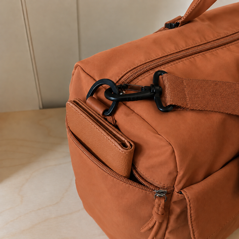 Orange — Sports Duffel Bag, close-up of the snap-front pocket, zip pull and round pouch