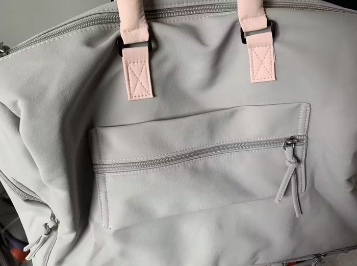 A buyer's photo of the Grey-Pink duffel's front flap and pocket